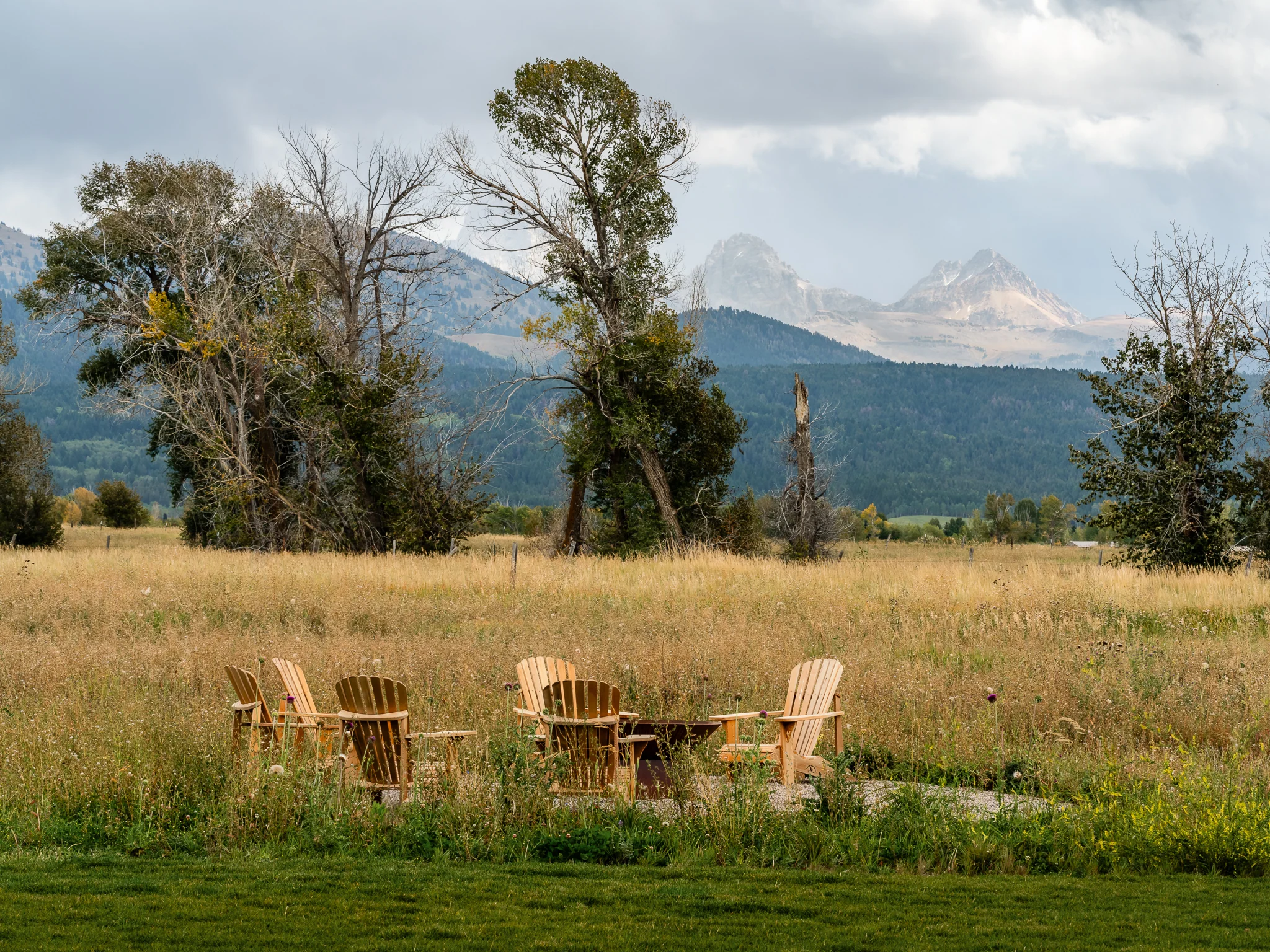 Fire pit and Adirondack chairs in an open meadow facing the Teton Range — architectural photography Driggs Idaho, WTG Architects
